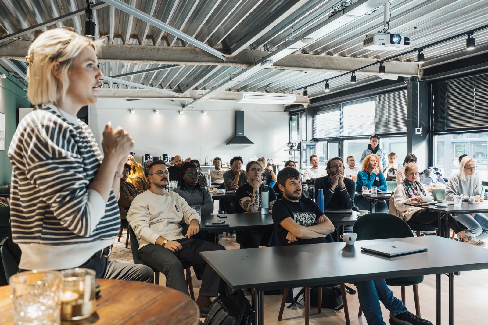 Intervenante devant un groupe réuni dans un espace de travail lors d’un événement d’entreprise