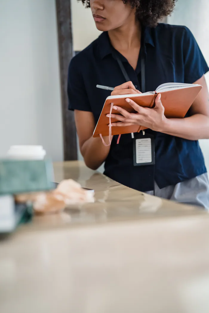 Professionnelle prenant des notes lors de la visite préparatoire d’un lieu événementiel