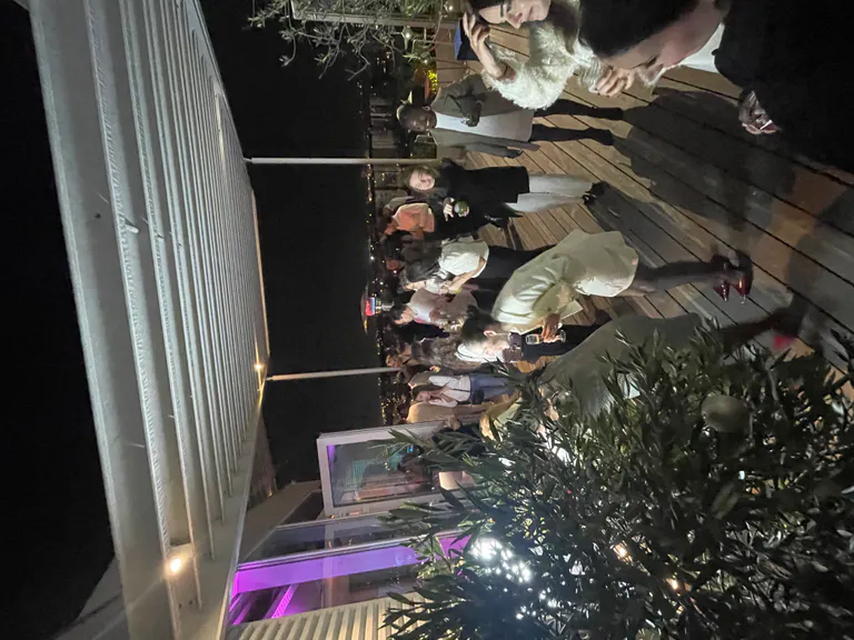 Soirée d'entreprise sur une terrasse avec des collaborateurs réunis à la nuit tombée