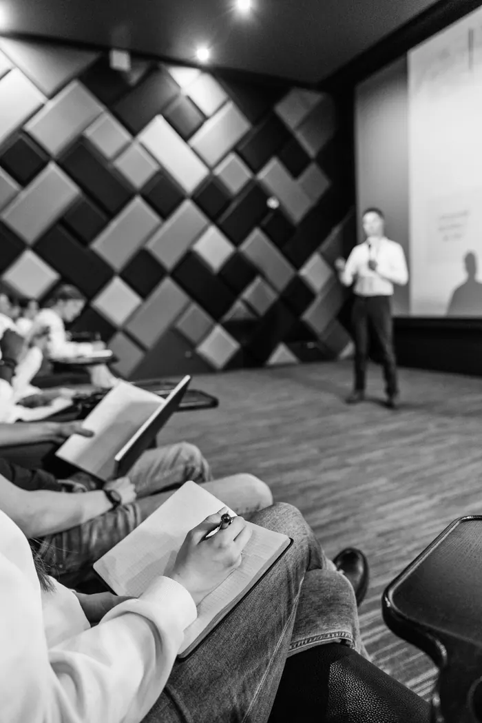 Participant prenant des notes pendant un séminaire d'entreprise