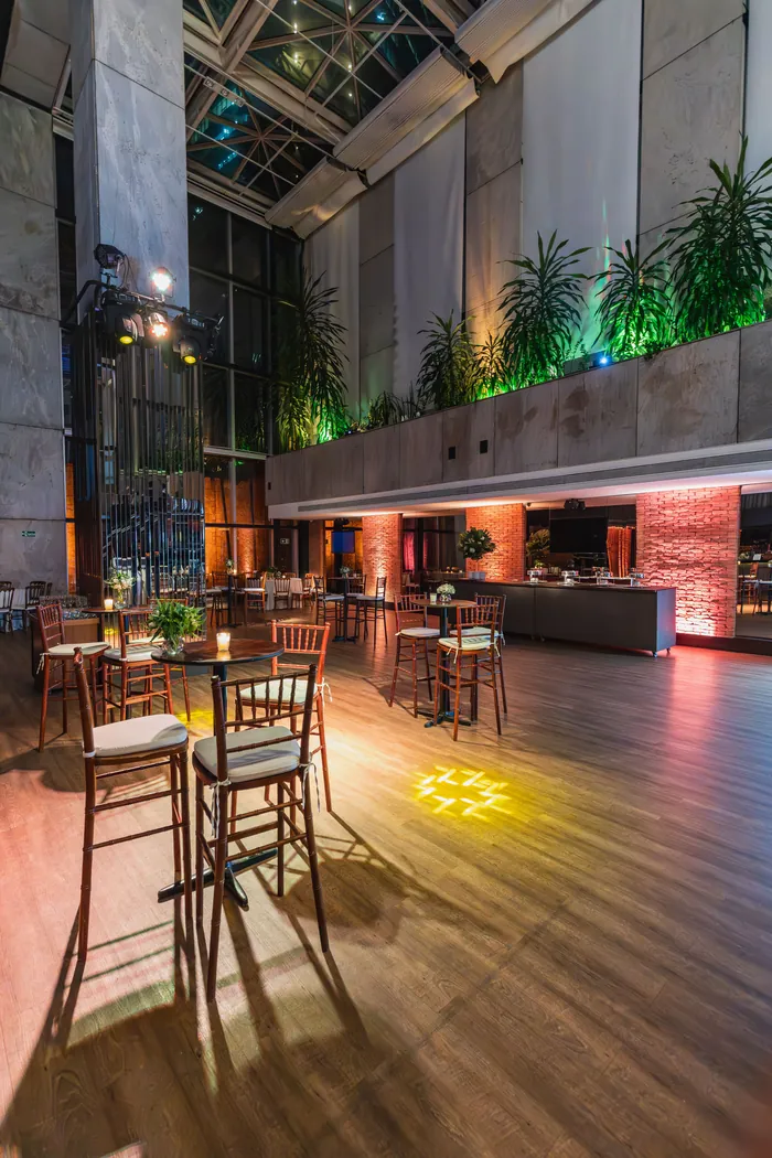 Lieu de réception aménagé pour une soirée d’entreprise avec tables hautes et éclairage d’ambiance